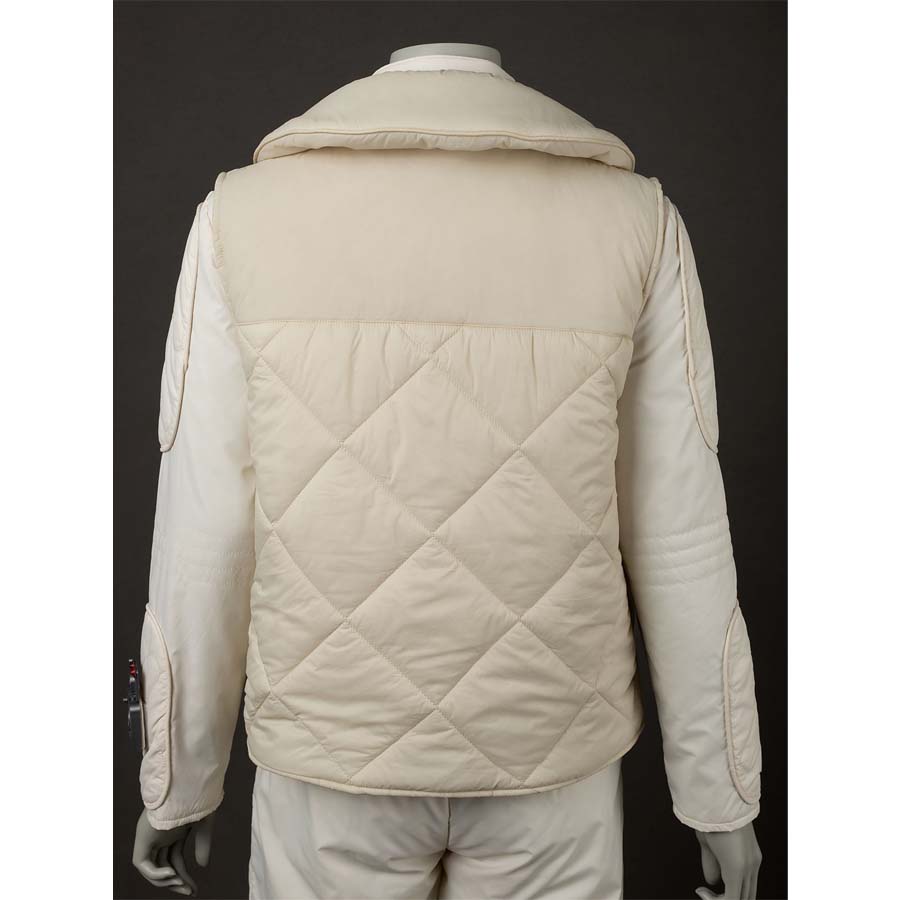 Back view of the vest over the jumpsuit, showcasing the quilted pattern and the hood. Highlights the overall back design.