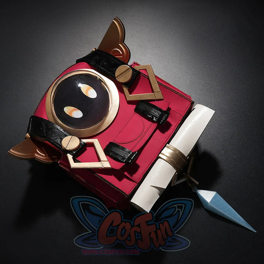 Close-up of Genshin Impact Linnea cosplay red backpack featuring Nod-Krai face design and gold hardware on dark background