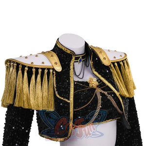 Close - up of the jacket and top. Features gold tassels, sequins, layered necklaces, and a decorative flower, highlighting intricate craftsmanship.