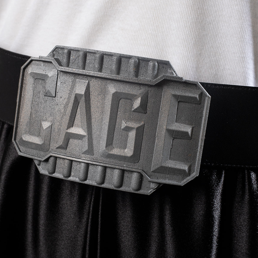 Belt buckle embossed with “CAGE”, highlighting the character’s signature style.