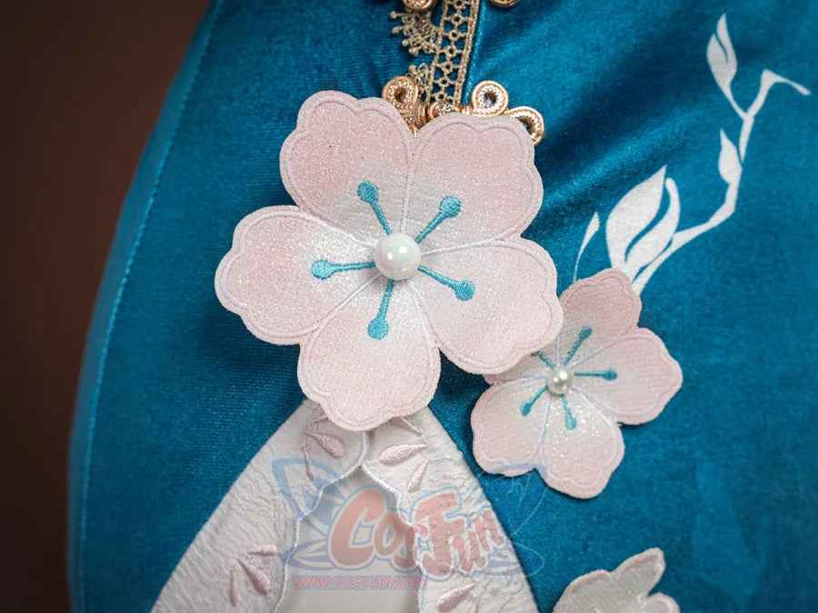 Ruan Mei cosplay costume close-up of pink plum blossom appliques with pearl centers on the teal skirt fabric.