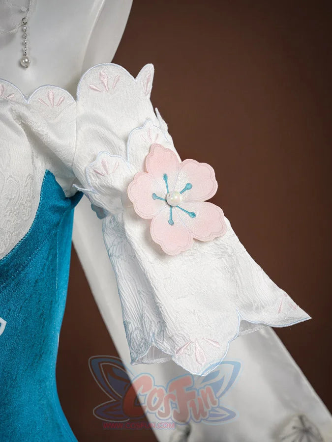 Ruan Mei cosplay costume detail showing a pink plum blossom applique on the white sleeve against teal blue fabric.