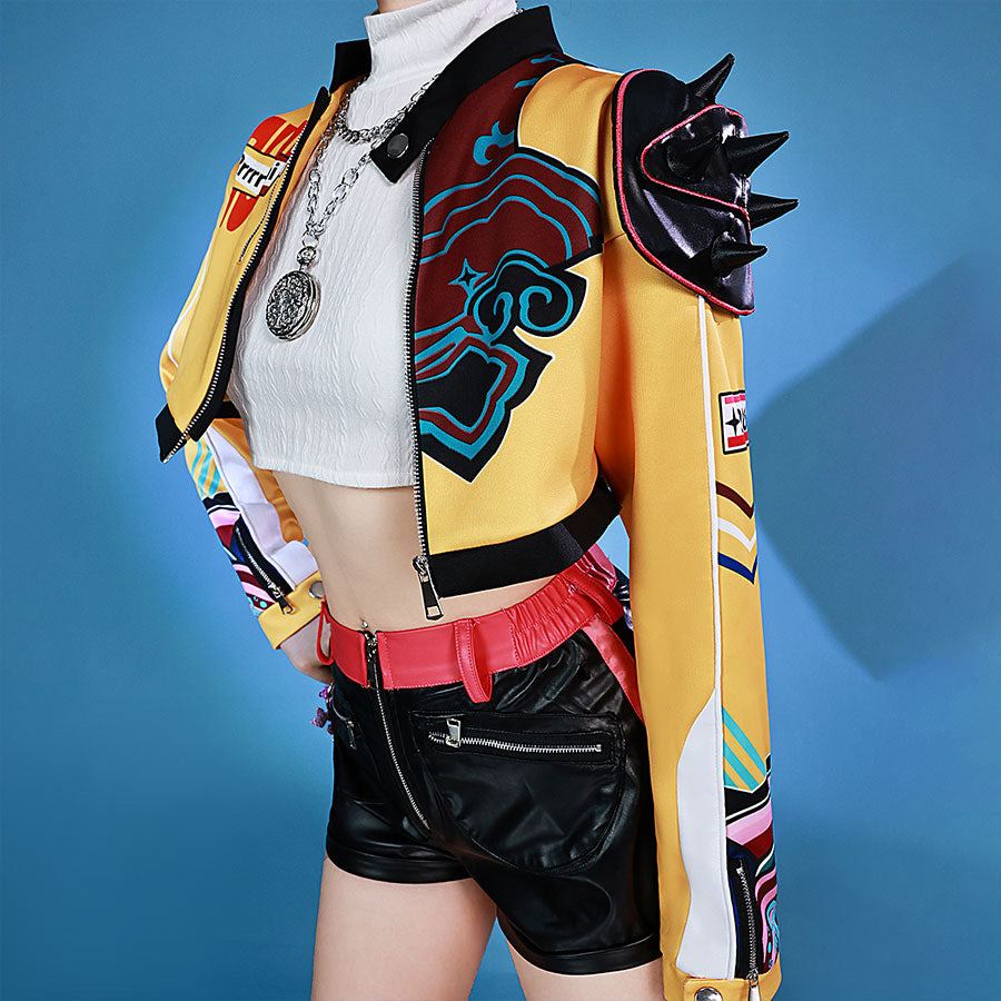 Idol Rumi cosplayer wearing a colorful jacket and black shorts on a blue background