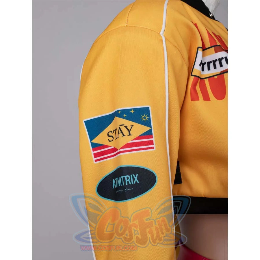 Close - up of patches on the sleeve of Rumi’s yellow cosplay jacket, featuring “STAY” and “AMTRIX” designs.