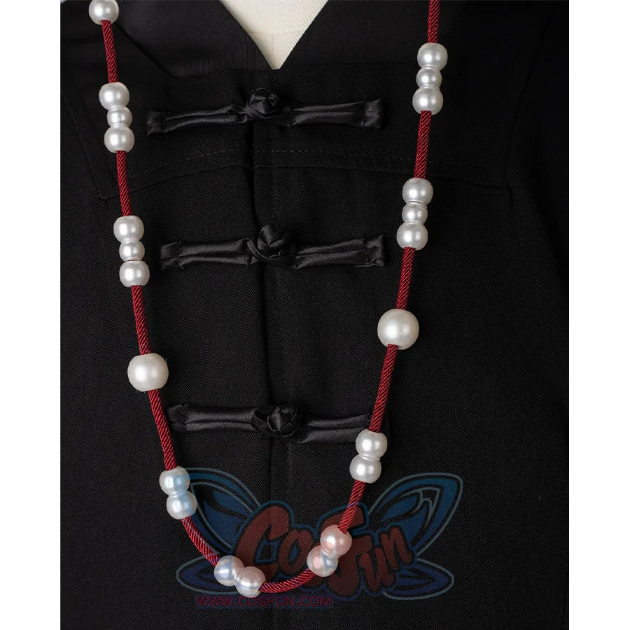 A black hat with red strings on both sides, adorned with white round beads.