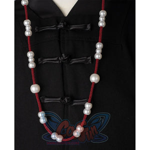 A black hat with red strings on both sides, adorned with white round beads.