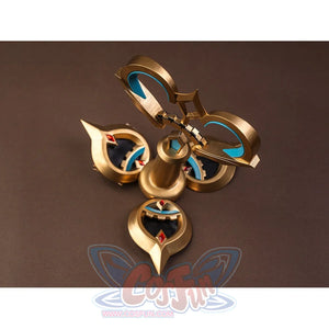 Sandrone cosplay costume back ornament flat lay showing gold piece with teal crescent inlays, red gems, and bell-shaped center