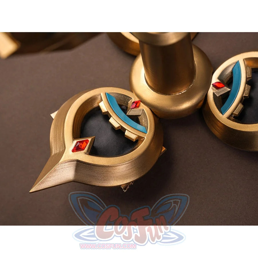 Sandrone cosplay costume back ornament macro detail showing gold crescent elements with teal inlay and red diamond gem accents