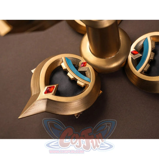 Sandrone cosplay costume back ornament macro detail showing gold crescent elements with teal inlay and red diamond gem accents
