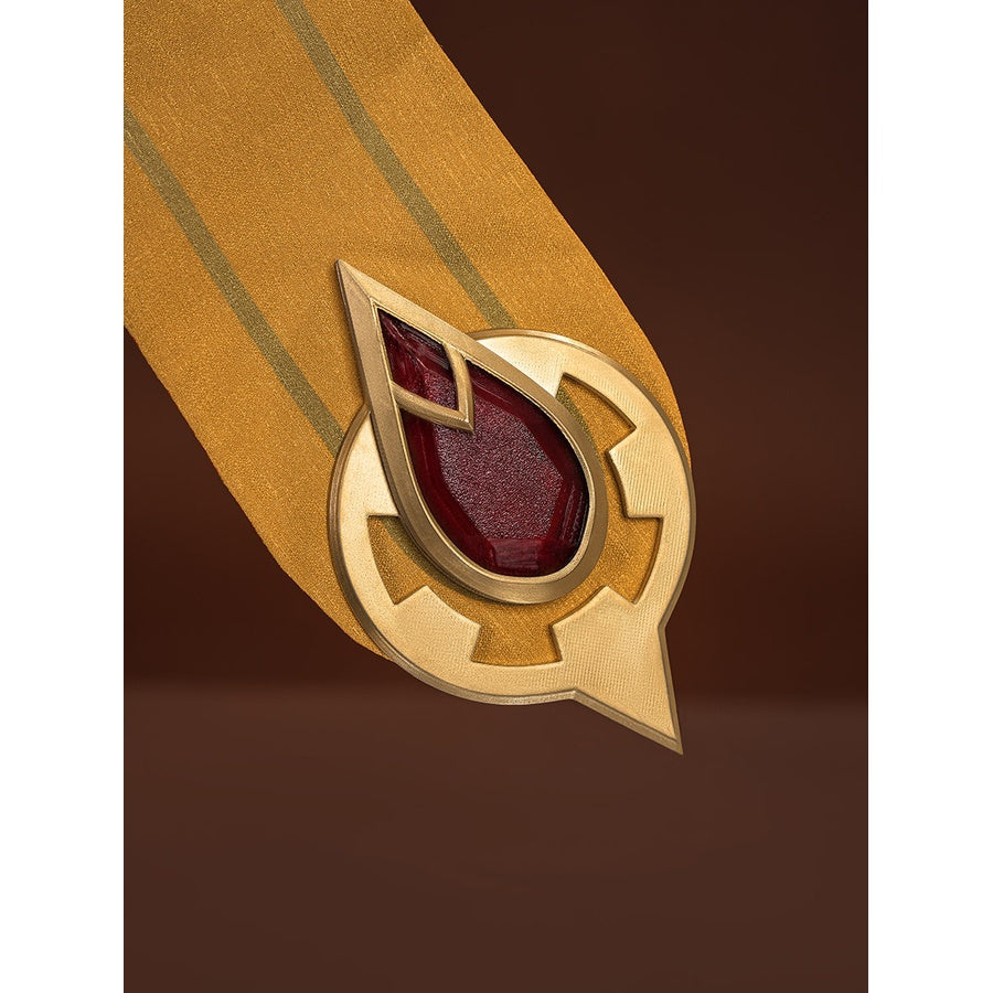 Sandrone cosplay costume skirt panel tip closeup showing circular gold mount with downward arrow and large red teardrop gem