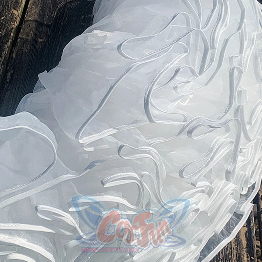 Close-up of a white, textured fabric with wavy patterns on a wooden surface.