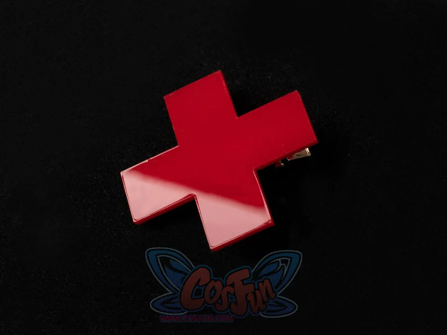 Starfire cosplay costume accessory, glossy red cross-shaped hair clip with gold clasp, shown on black background