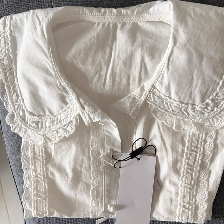 Flat lay of white Lolita blouse highlighting the wide lace-edged Peter Pan collar and eyelet lace front placket.
