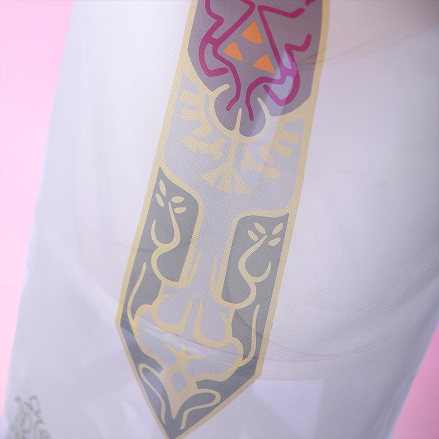 Detailed close-up of the Princess Zelda crest emblem on the cosplay sheer skirt, with multicolor print in pink, gold, and gray on white.