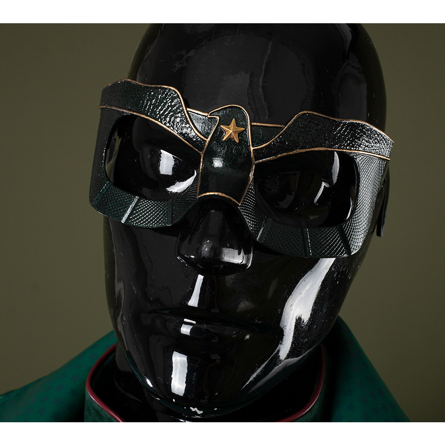 The mask is entirely black, adorned with golden bird-like lines and a star motif in the center.