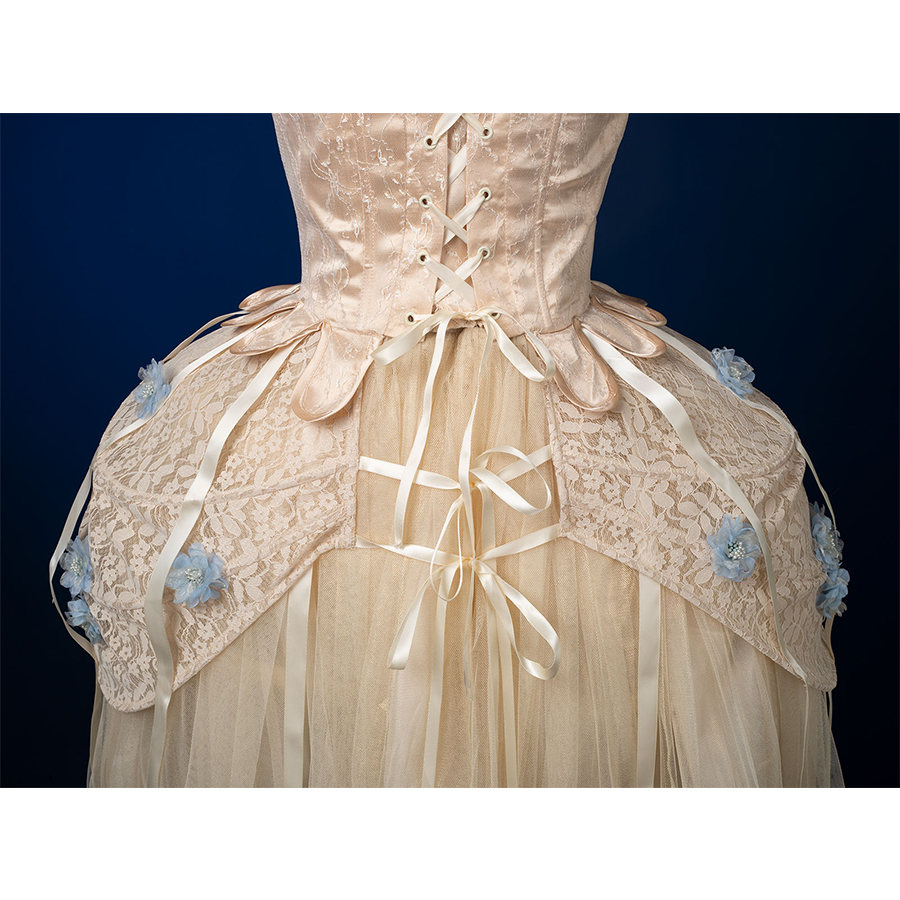 Enid Sinclair Gala dress side skirt back view with corset, blue floral appliques, cream lace, ribbon bows, layered tulle