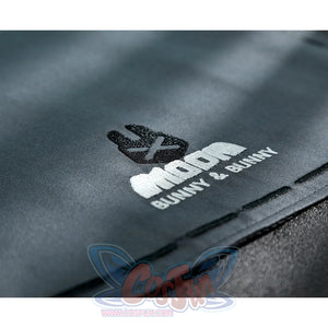 Zhao cosplay costume apron edge close-up showing Moon Bunny & Bunny logo embroidery on gray fabric with decorative stitching