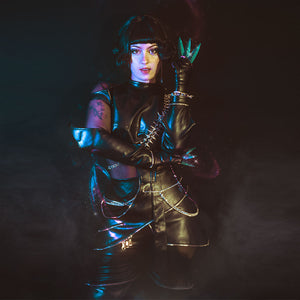 Cosplayer wearing Zoey cosplay KILLER black suit with high collar, metal chains, and purple ornaments