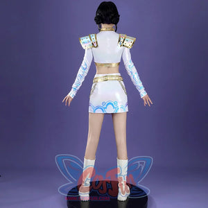 From the back, Zoey’s cosplay reveals iridescent shoulder armor, gold - lined crop top and skirt waist, patterned sleeves, and blue skirt designs, paired with white boots on a purple backdrop.