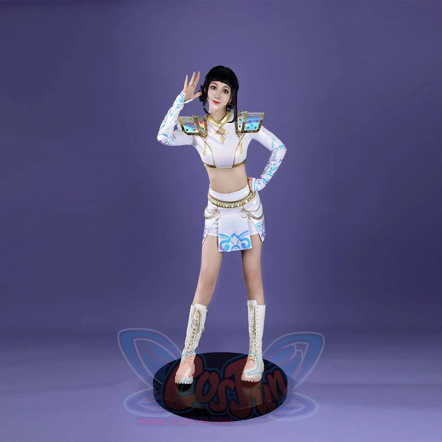 From the front, Zoey’s cosplay displays gold - detailed shoulder armor, a crop top with a central gold motif, a chain - belted skirt with blue patterns, and white boots, set against a purple backdrop.