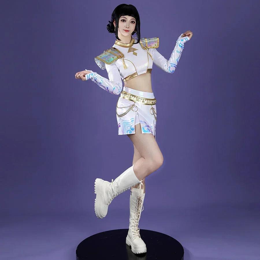 The cosplayer strikes a dynamic pose, highlighting Zoey’s costume with iridescent shoulder armor, gold - trimmed crop top, patterned sleeves, and a skirt adorned with chains, all paired with white lace - up boots against purple.