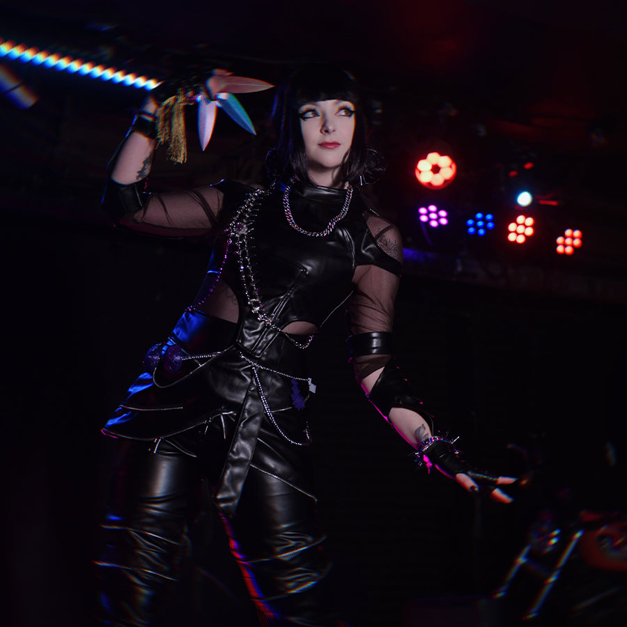  Cosplayer in Zoey cosplay KILLER black suit showing side view with metal chains and purple details
