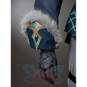 Aether cosplay cuff detail with gray fluffy trim and a gold-tone ornament over a dark teal sleeve.