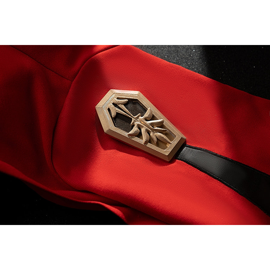 Genshin Impact Amber cosplay armband accessory detail sets a gold-tone emblem over red fabric.