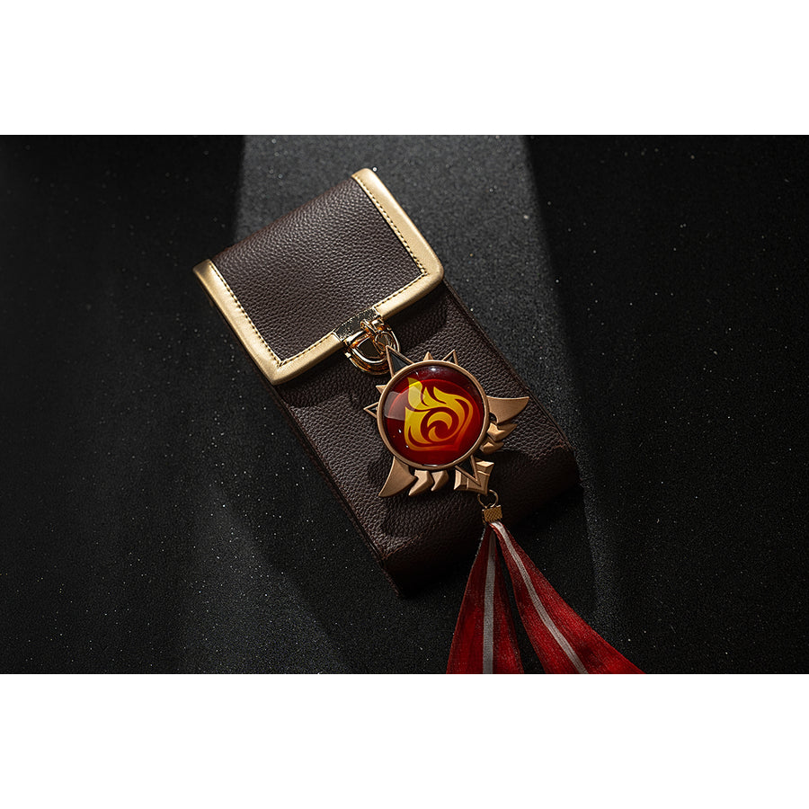 Genshin Impact Amber cosplay vision tassel flat lay pairs the gold-tone emblem with red flame ribbons.