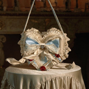 Blue heart handbag front view with lace ruffles, satin bow layers, and cherry accents