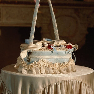 Side view of the blue heart handbag showing ruffled lace, zipper, and handle structure