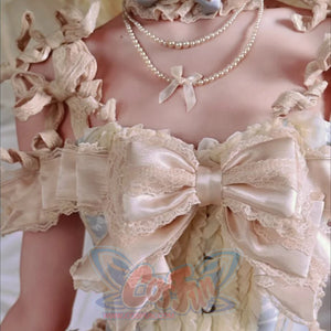 Close-up of the corset top bow, pearl trim, lace ruffles, and front button details