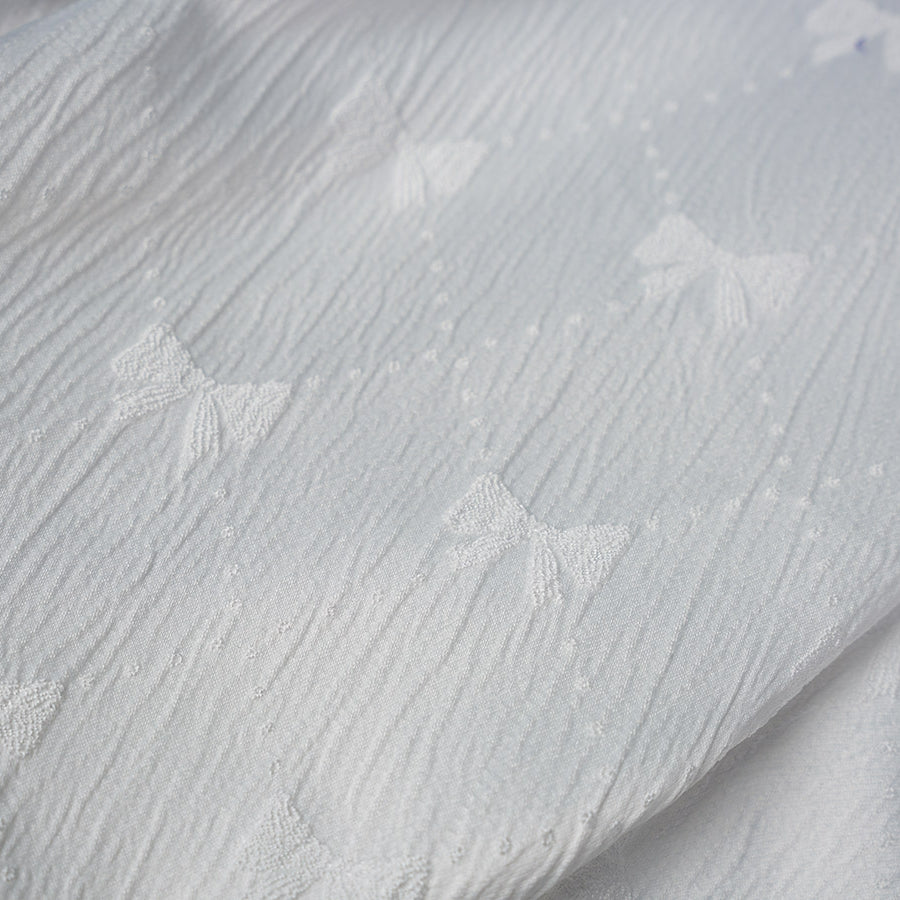 Honkai: Star Rail Castorice Gossamer Flutter cosplay costume white fabric texture beside embroidered bow patterns.