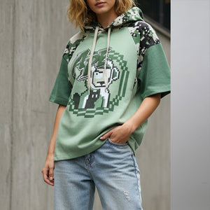 Model wearing green summer camo monkey shirt hoodie with pixel art design and camo sleeves