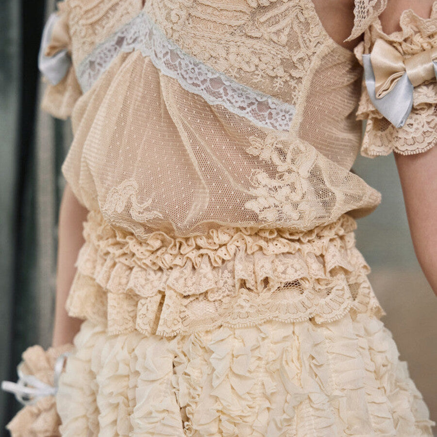 Close-up of the camisole ruffled hem, sheer dotted mesh, and cream lace texture