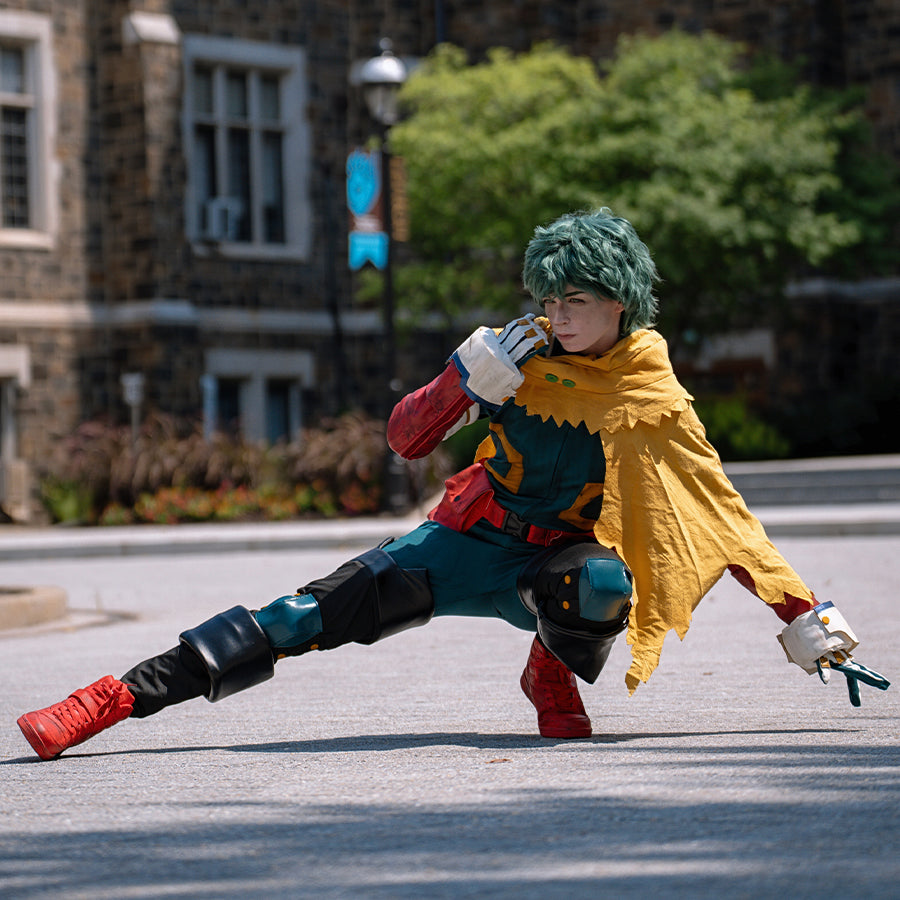 COSFUN Deku cosplay costume crouched pose layers a yellow cape over a teal bodysuit and red arm guards.