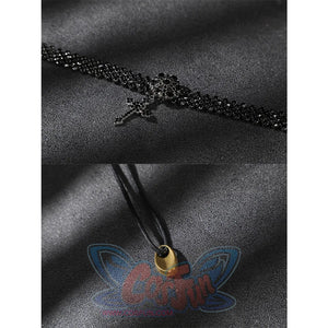 Close-up of a black beaded choker-style accessory and a black cord with a small gold-toned end piece.