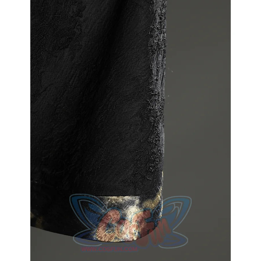 Close-up of the Fire Keeper cape hem showing the black textured fabric and softly reflective metallic edge trim.