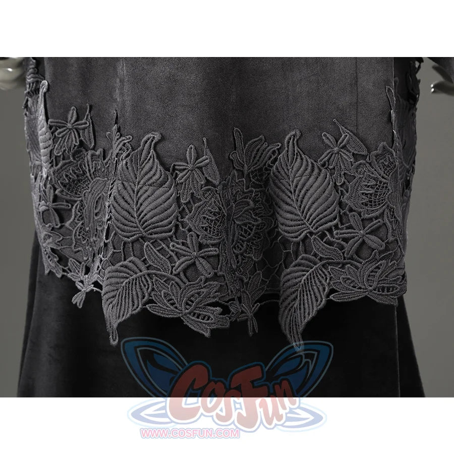 Close-up of the lower outer dress hem featuring layered black floral embroidery over the long black skirt.