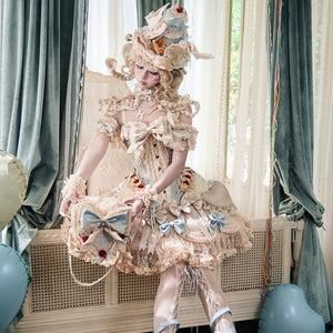 Full Lolita styling with cream lace bodice, layered skirt, and blue ribbon accents