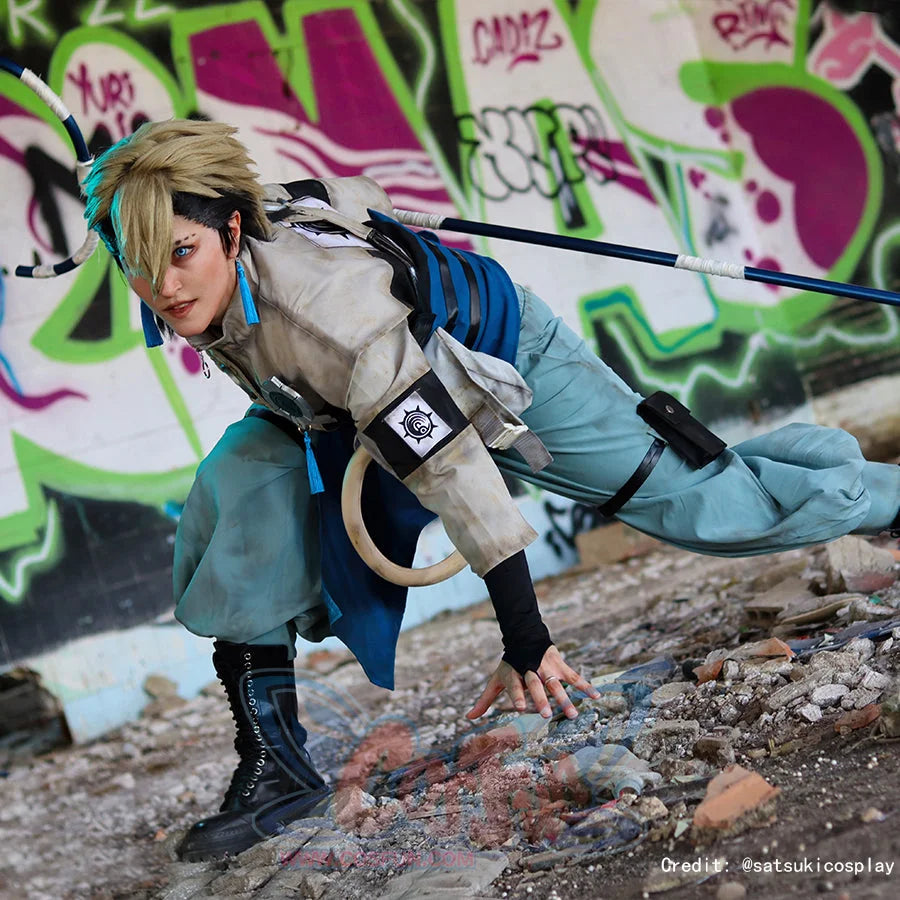 Gachiakuta Zanka Nijiku cosplay costume crouches low, blue sash layers above a pouch and black boot