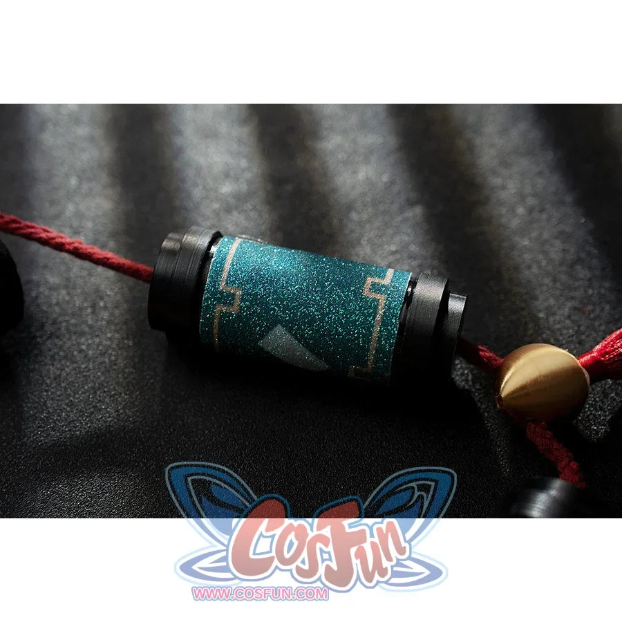 Genshin Impact Yanfei cosplay tassel detail ties teal textured fabric to a red cord and gold bead.
