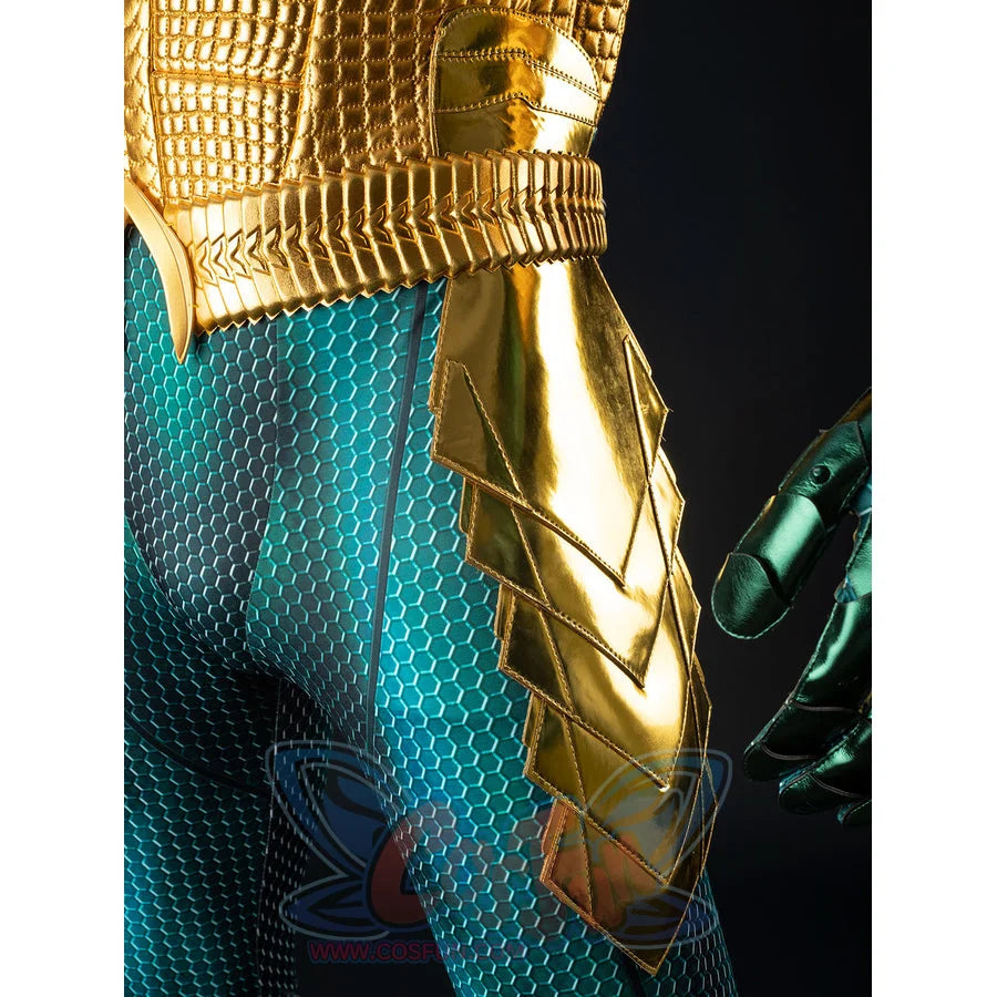 Gold-tone armored cosplay thigh guard detail curves pointed panels over teal scale fabric at the side.