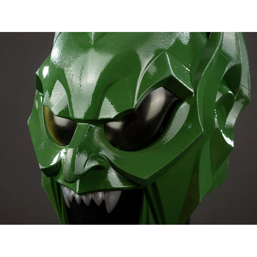 Green Goblin Norman Osborn cosplay helmet eye close-up sets black lenses inside angular green armor.
