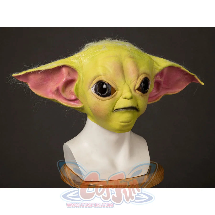 Grogu cosplay headpiece and claws curve into wide pointed ears that frame the character face with deep textured skin.
