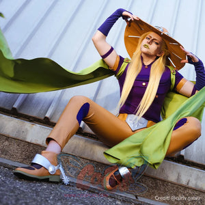 Anime Gyro Zeppeli cosplay costume spreads the green cloak around a seated purple top and tan pants look.