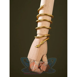 Worn view of Charlie Morningstar snake arm cuff with gold coiled shape, black eyes and wrapped bracelet form