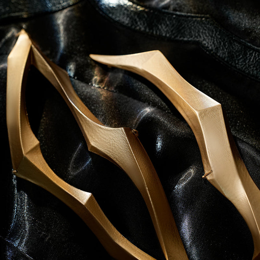 Honkai Star Rail Khaslana cosplay gold chest prop close-up reveals curved armor over the black coat