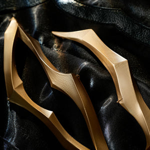 Honkai Star Rail Khaslana cosplay gold chest prop close-up reveals curved armor over the black coat
