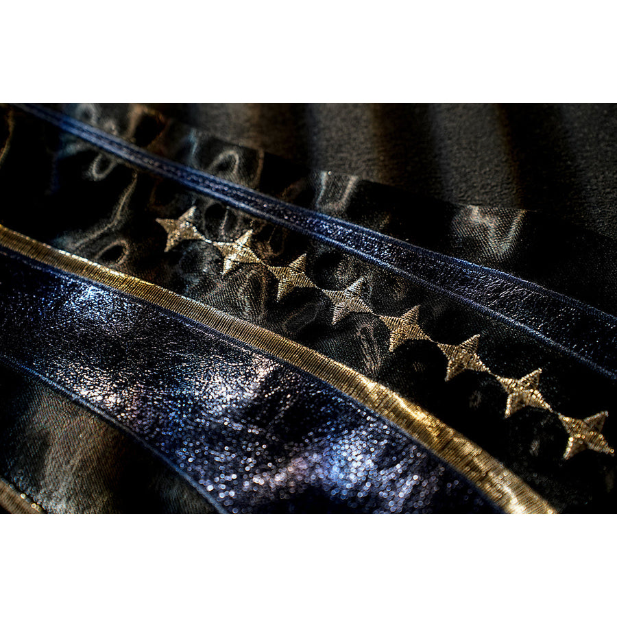 Honkai Star Rail Khaslana cosplay coat detail shows star accents set along blue-edged black fabric